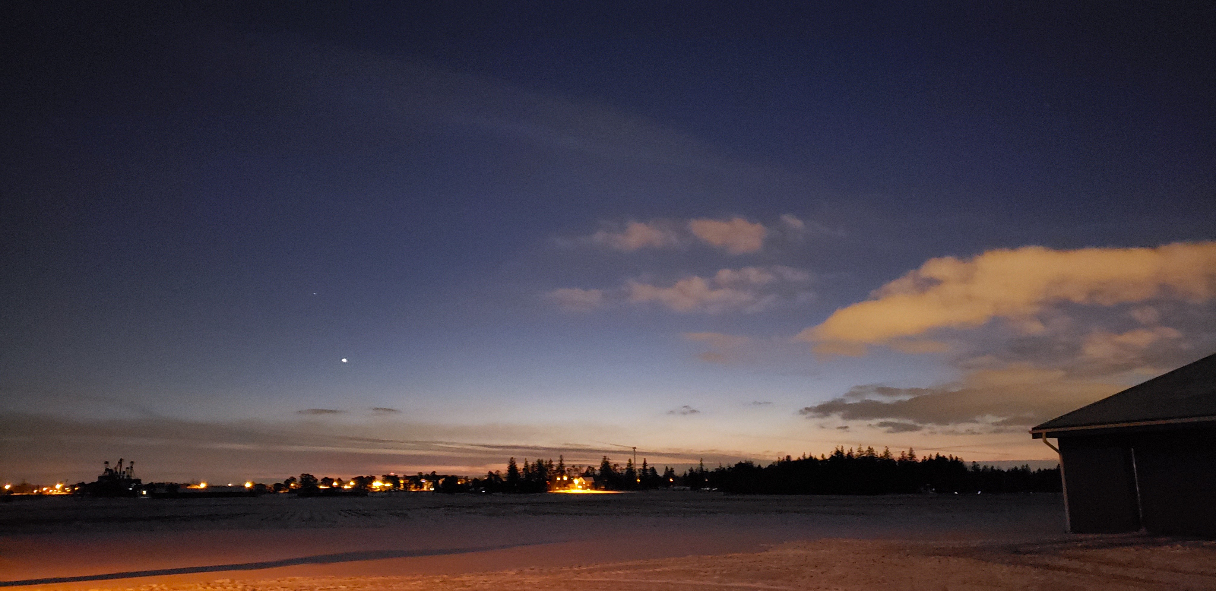 Outside the Arkell Poultry facility at night. There is snow on the ground, a dark blue sky and white clouds in the distance.