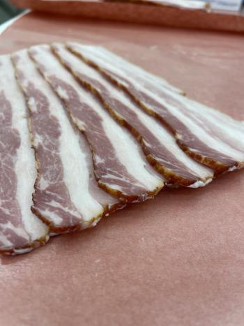 Several slabs of bacon cut up and placed in packaging